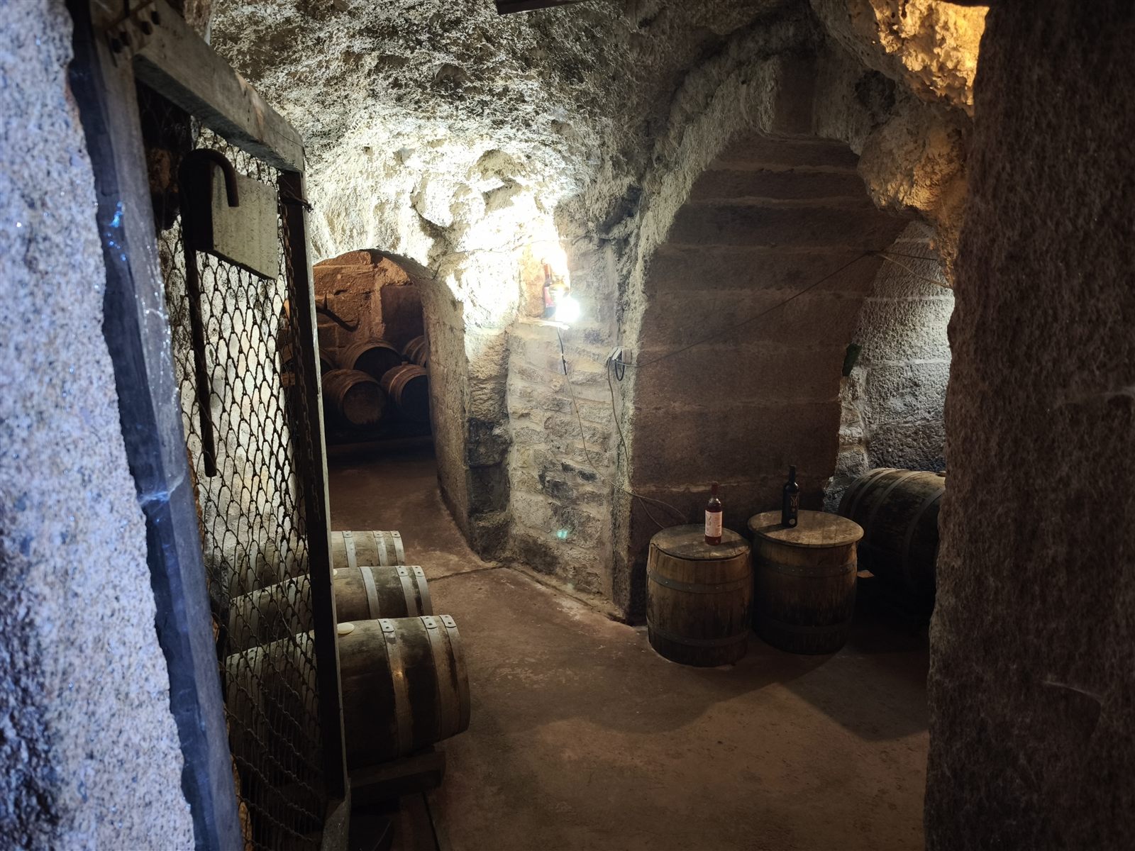 Galería subterránea con barricas y arcos de granito